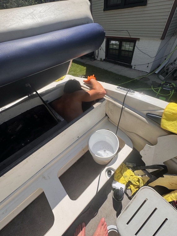 Cleaning inside a boat's storage compartment during a detail