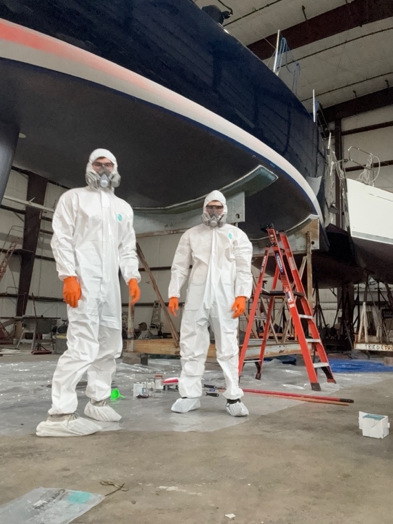 Hands On Deck crew prepping a hull for bottom paint in the yard