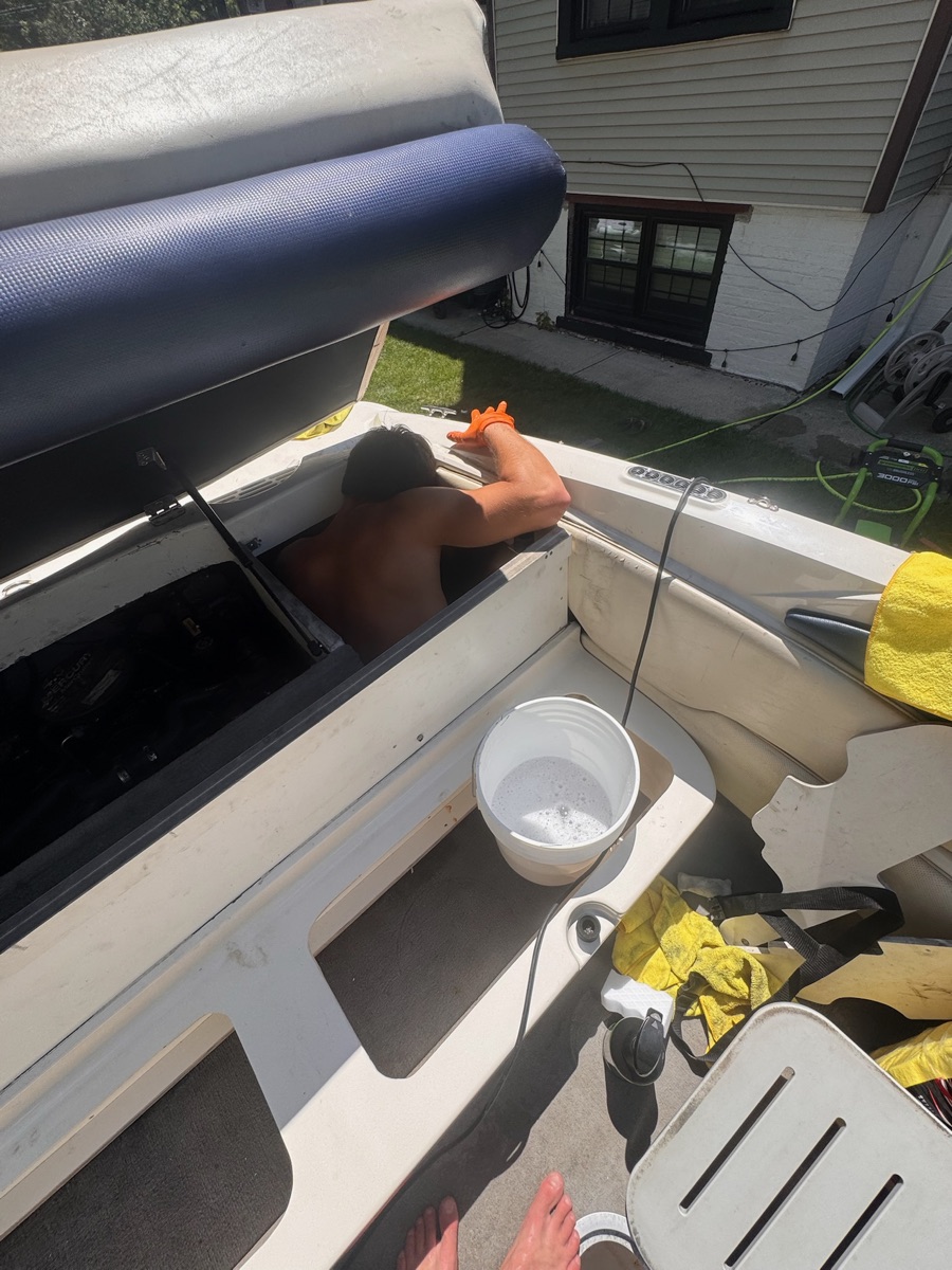 Cleaning inside a boat's storage compartment during a detail